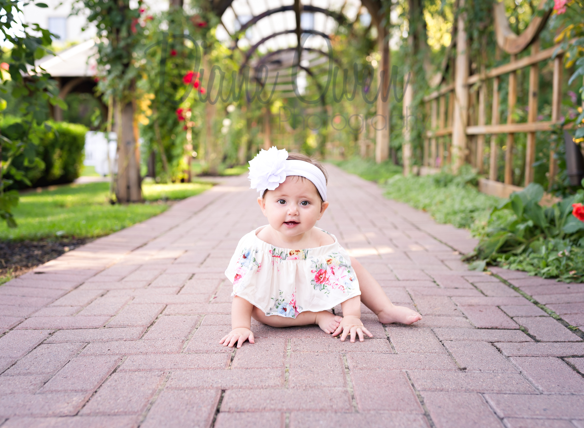 An adorable baby in a floral romper.
